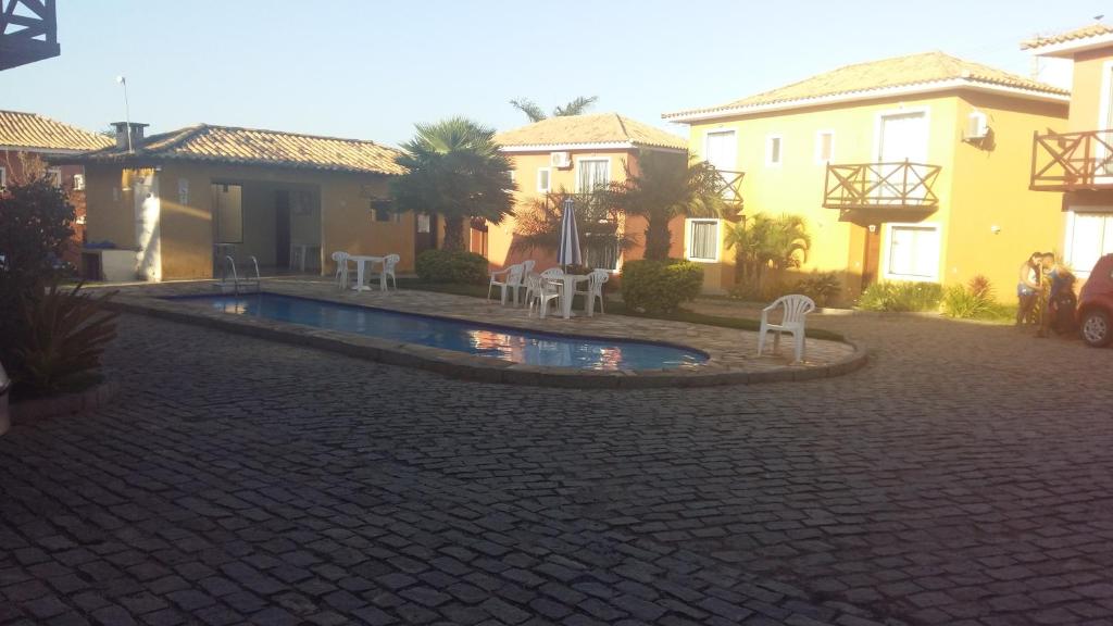 un patio con piscina frente a algunas casas en Casa em Búzios com vista para mar, en Búzios