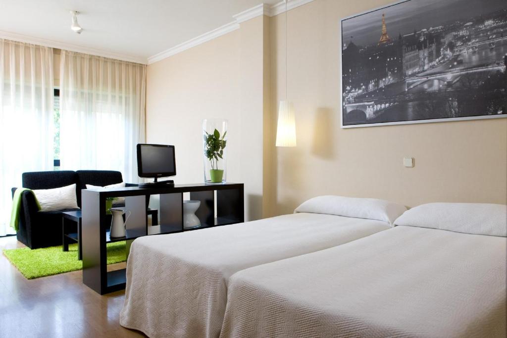 Schlafzimmer mit einem Bett und einem Schreibtisch mit einem Computer in der Unterkunft Apartamentos TH La Florida in Madrid