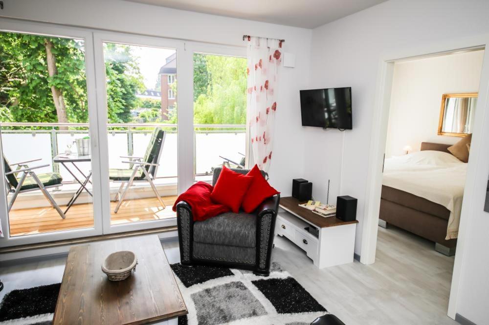 uma sala de estar com uma cama e uma cadeira e uma televisão em Ferienwohnung Strandvilla Augustusbad 14 em Scharbeutz