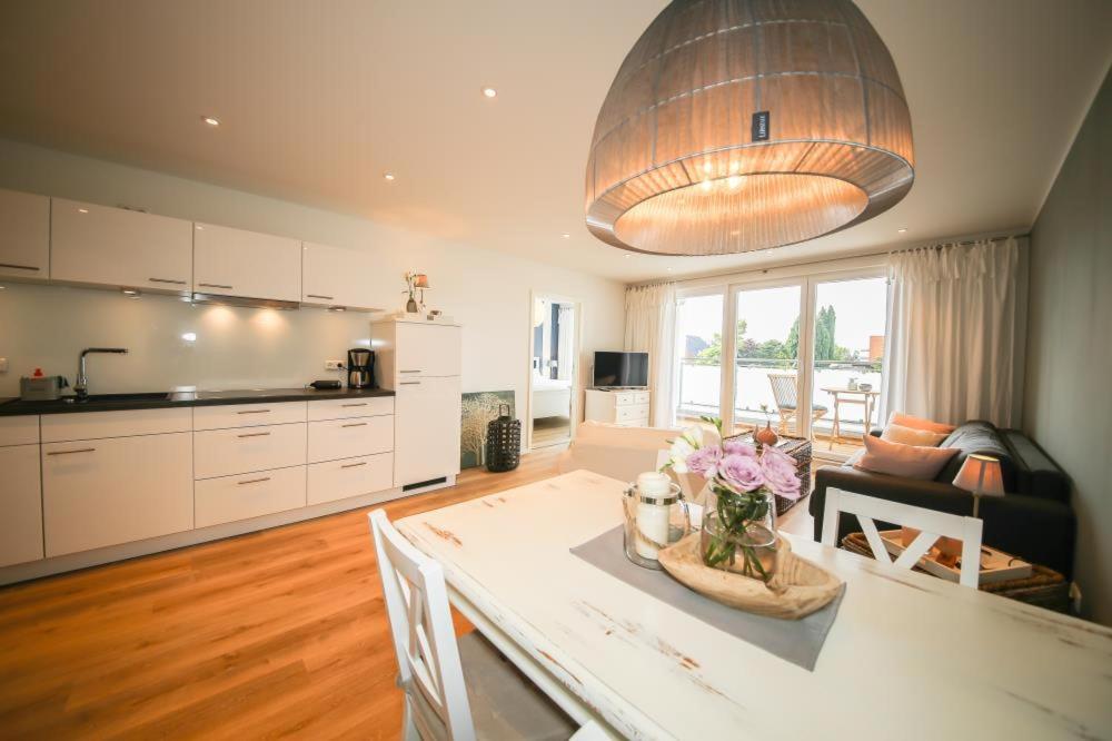 a kitchen and living room with a table with flowers on it at Ferienwohnung Strandvilla Augustusbad App. 08 in Scharbeutz