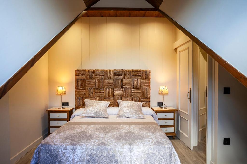 a bedroom with a large bed and two night stands at Apartamentos Casa Ríos in Biescas