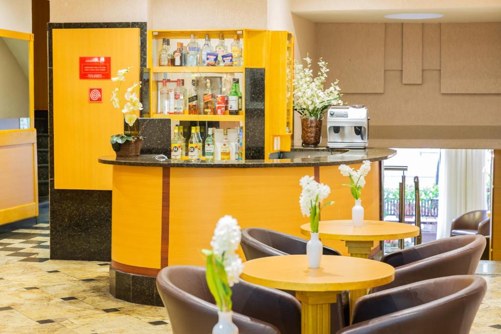a restaurant with tables and chairs and a yellow bar at Hotel Vermont Ipanema in Rio de Janeiro