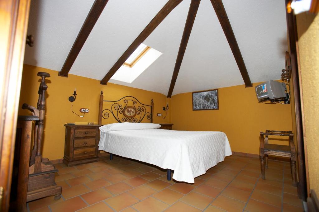 1 dormitorio con cama blanca y paredes amarillas en Hotel Posada San Antonio, en El Bosque