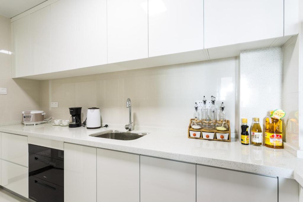 a kitchen with white cabinets and a sink at Wuhan Hongshan·Jiedaokou· Locals Apartment 00116860 in Wuhan