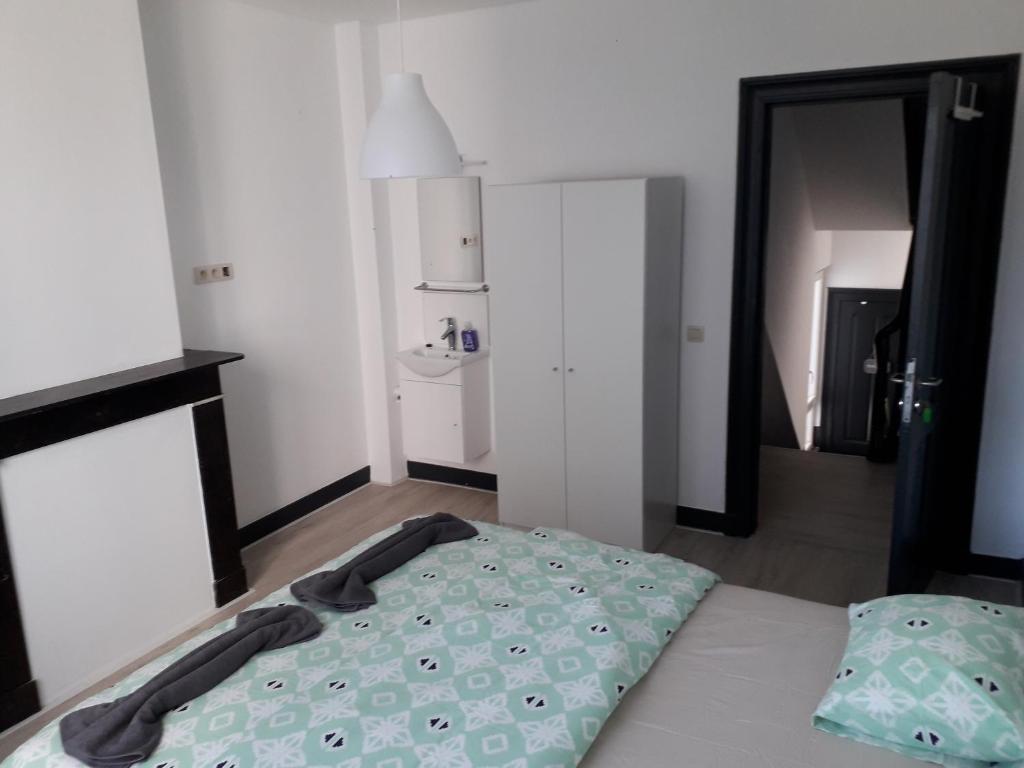 a bedroom with a bed and a door to a bathroom at Leonard room in Liège