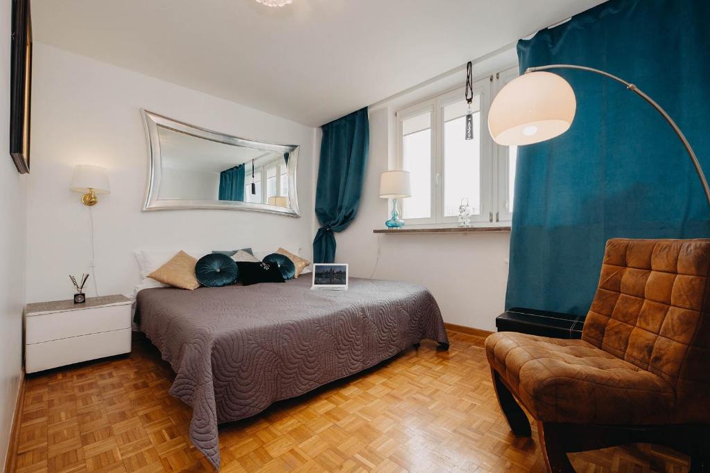 1 dormitorio con 1 cama y 1 silla con ordenador portátil en V Ajax Rondo ONZ, en Varsovia