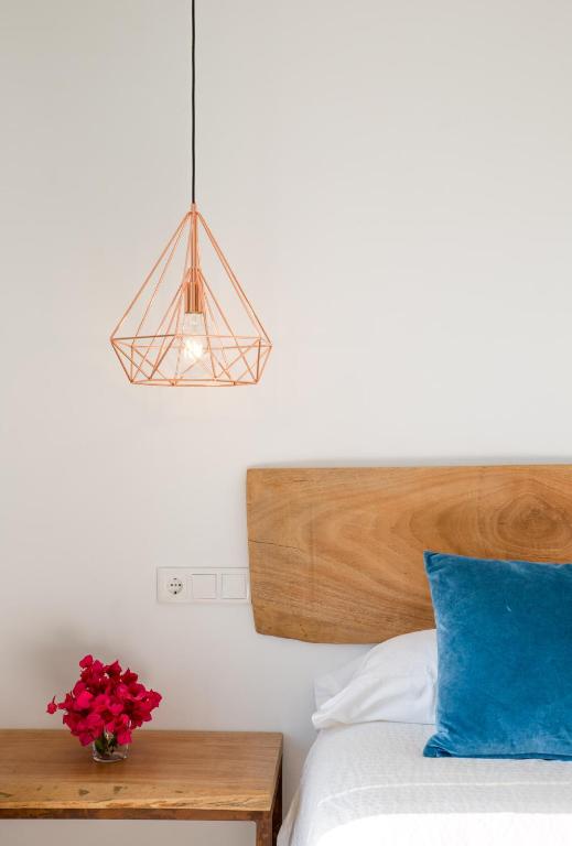 a bedroom with a bed with a blue pillow and a lamp at Fortuna in Los Caños de Meca