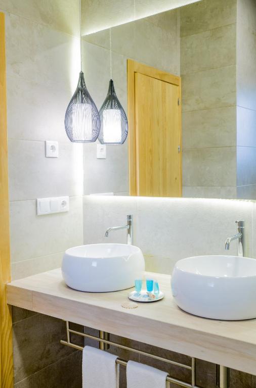 two sinks in a bathroom with two lights at Fortuna in Los Caños de Meca