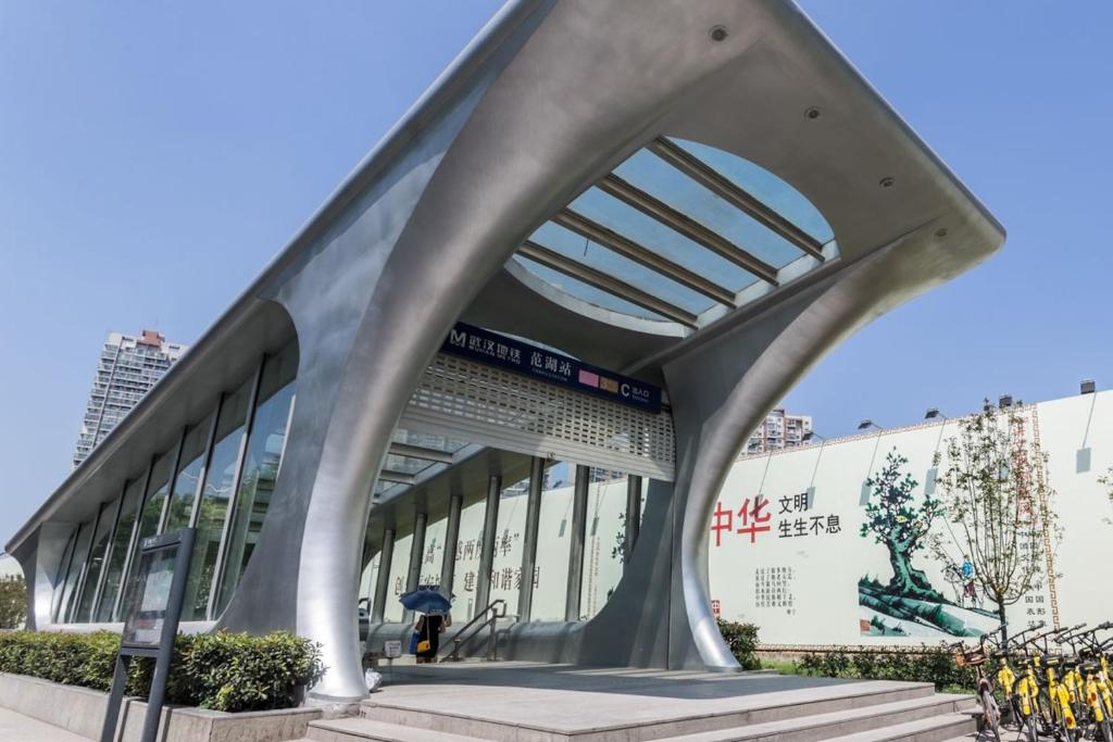 un bâtiment incurvé avec des escaliers en face d'un bâtiment dans l'établissement Wuhan Jianghan·Hankou Railway Station· Locals Apartment 00120600, à Wuhan