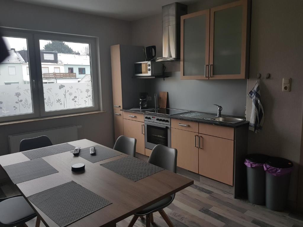 uma cozinha com uma mesa e cadeiras e uma cozinha com uma janela em Ferienhaus Thalia 2 em Übach-Palenberg