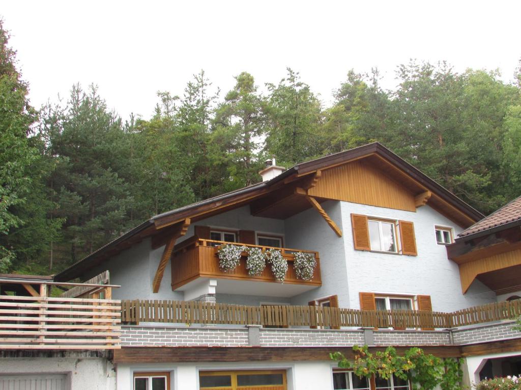 una casa con balcone e alberi sullo sfondo di Ferienhaus Tschenett a Imst