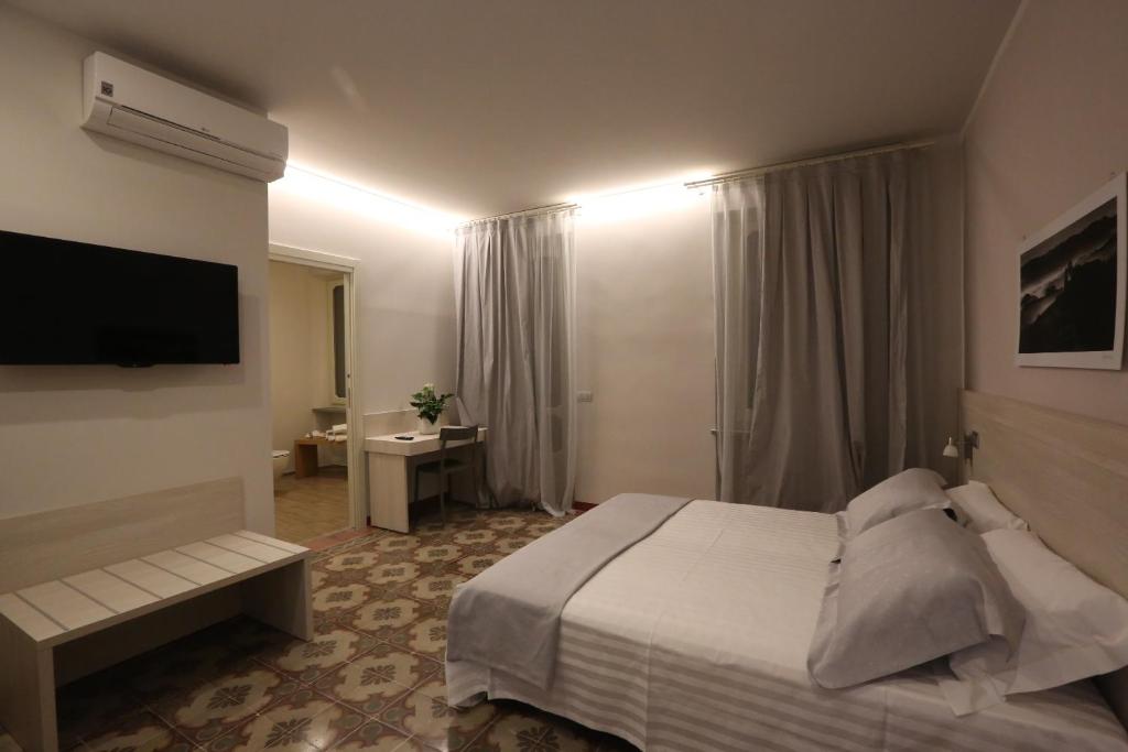 una camera con letto e TV a schermo piatto di Palazzo Belli ad Alba