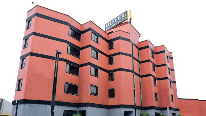 ein rotes Gebäude mit einem Schild darüber in der Unterkunft Hotel Siesta del Sur in Mexiko-Stadt