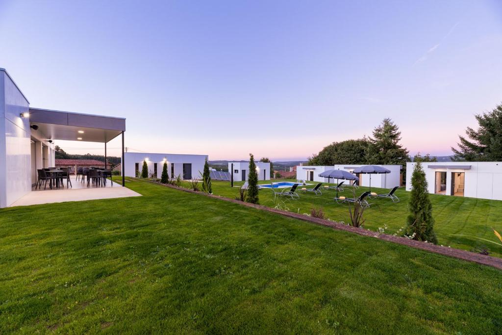 a house with a yard with green grass at Hotel A Curuxa Wellness in Arzúa
