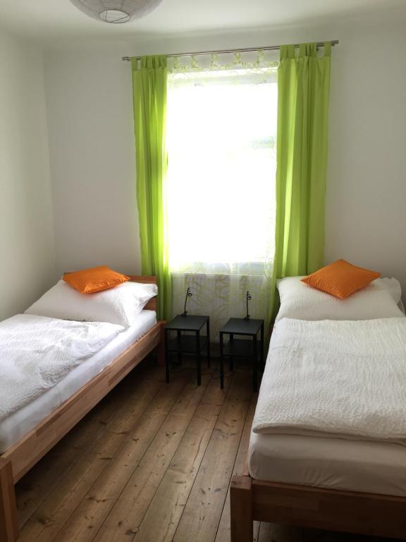 2 łóżka w pokoju z oknem z zielonymi zasłonami w obiekcie Ferienhaus Karoline w mieście Pulkau
