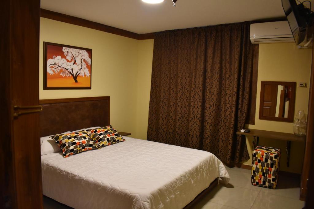 a bedroom with a bed and a window at Hotel Bonanza in Guayaquil