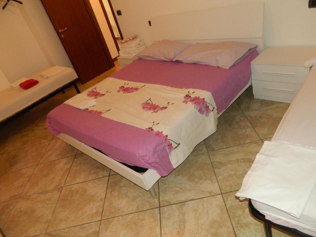 a bedroom with a bed with pink flowers on it at Appartamento Mira in Cislago