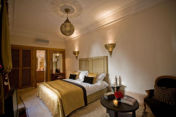 1 dormitorio con cama extragrande y mesa en Riad Zamzam, en Marrakech