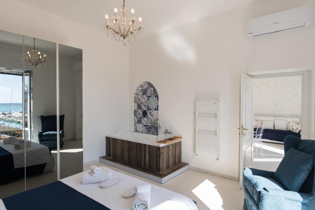 a living room with a bed and a mirror at Relais Mareluna - Luxury Apartments in Salerno