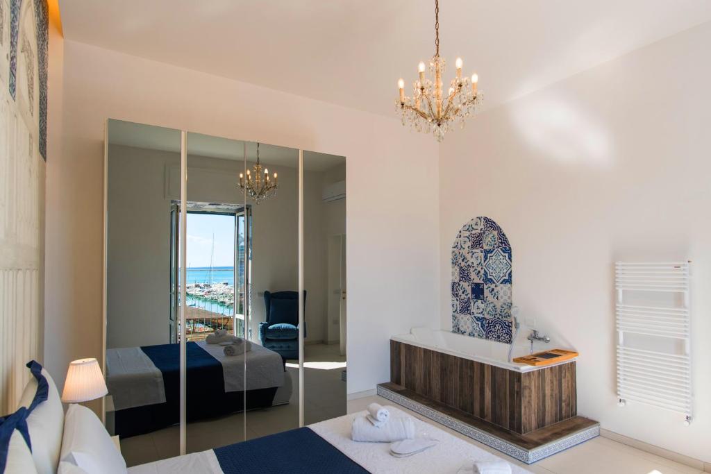 a bedroom with a bed and a mirror at Relais Mareluna - Luxury Apartments in Salerno