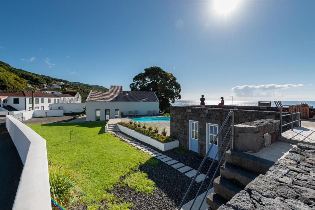 een uitzicht op de achtertuin van een huis met de oceaan op de achtergrond bij T2 Lux Casa das Pereiras in Calheta de Nesquim