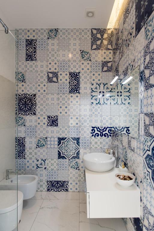 a bathroom with blue and white tiles on the wall at Relais Mareluna - Luxury Apartments in Salerno