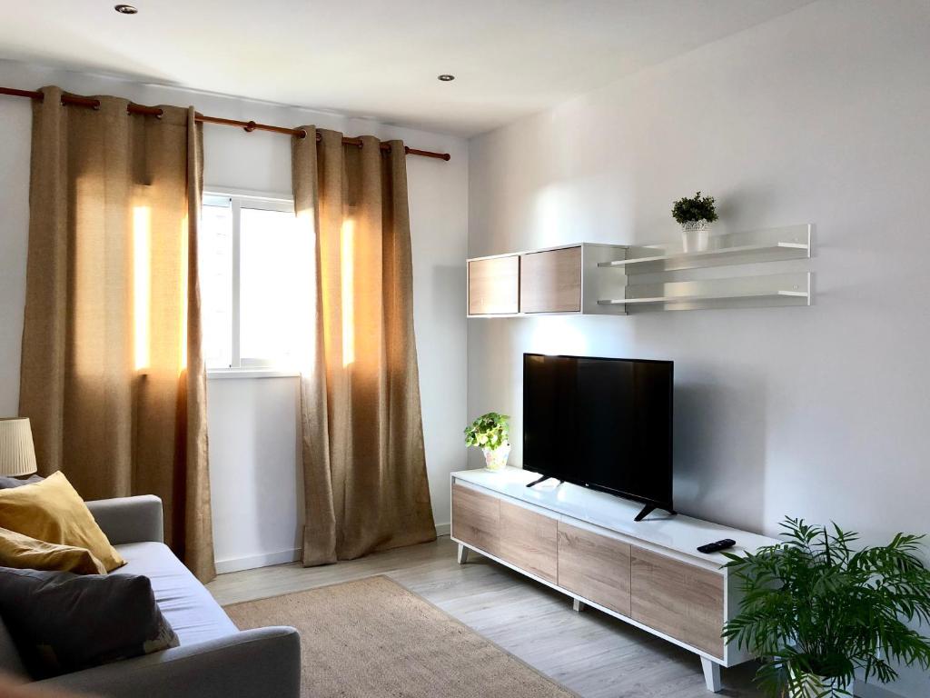 sala de estar con TV de pantalla plana en la pared en Apartamento de la Candelaria I, en Santa Cruz de Tenerife