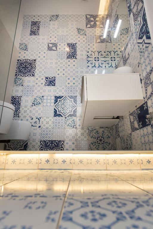 a bathroom with a sink and blue and white tiles at Relais Mareluna - Luxury Apartments in Salerno
