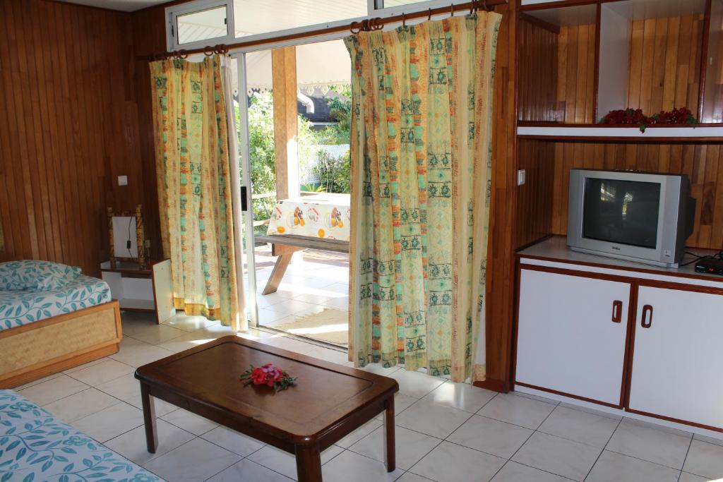 a living room with a tv and a table at Fare Edith Moorea in Haapiti