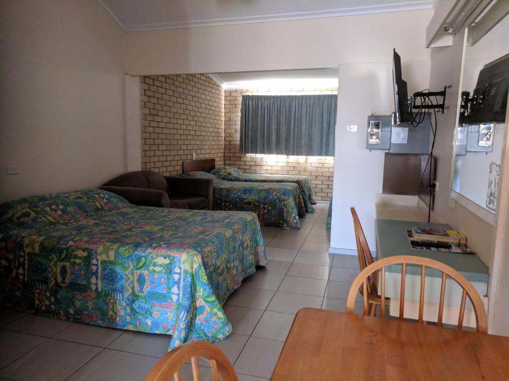 una camera d'albergo con due letti e un divano di Best One Motel a Rockhampton