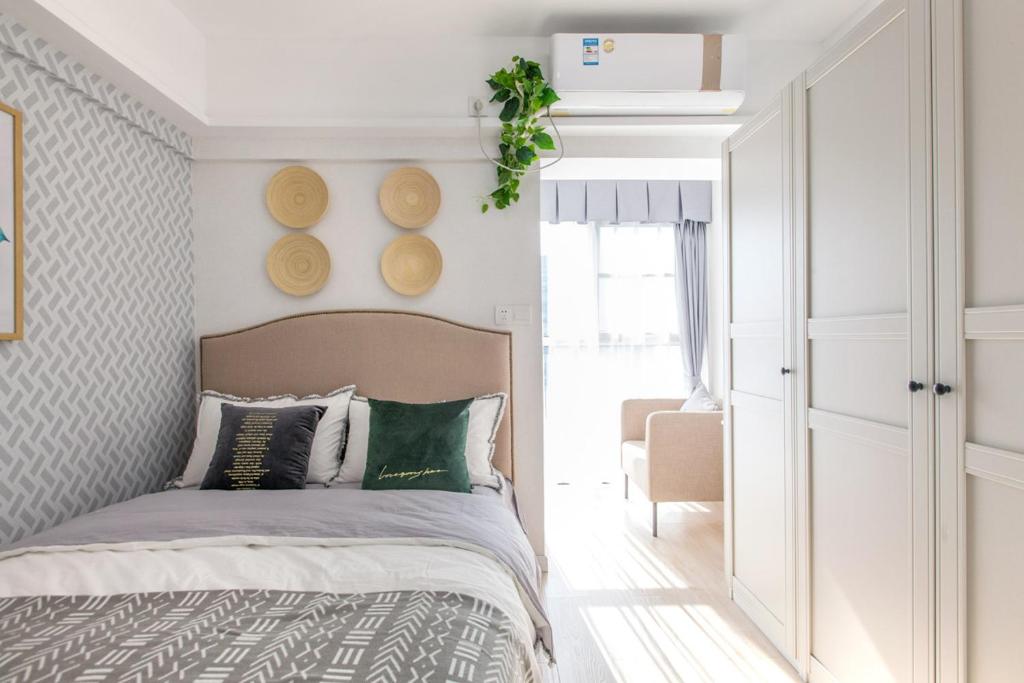 - une chambre avec un lit et des oreillers verts dans l'établissement Wuhan Wuchang·Hualin Huabu Lane· Locals Apartment 00142780, à Wuhan