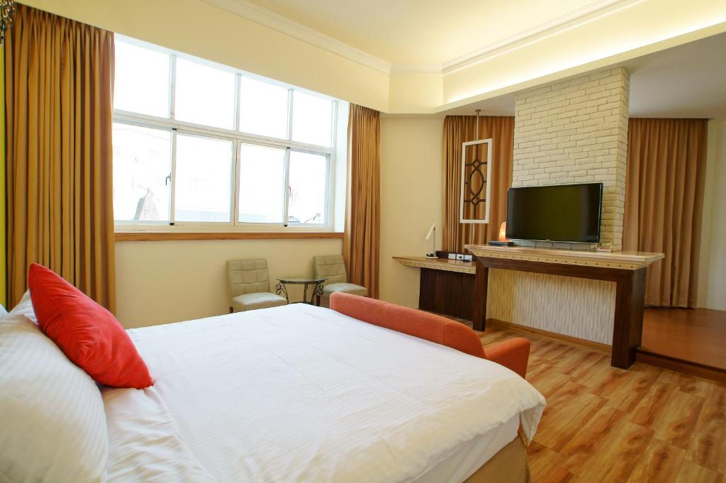 a hotel room with a bed and a flat screen tv at Taitung Venice B&B in Taitung City