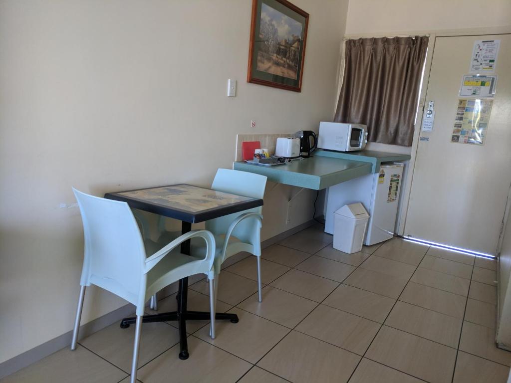 
a kitchen with a table and chairs and a sink at Best One Motel in Rockhampton
