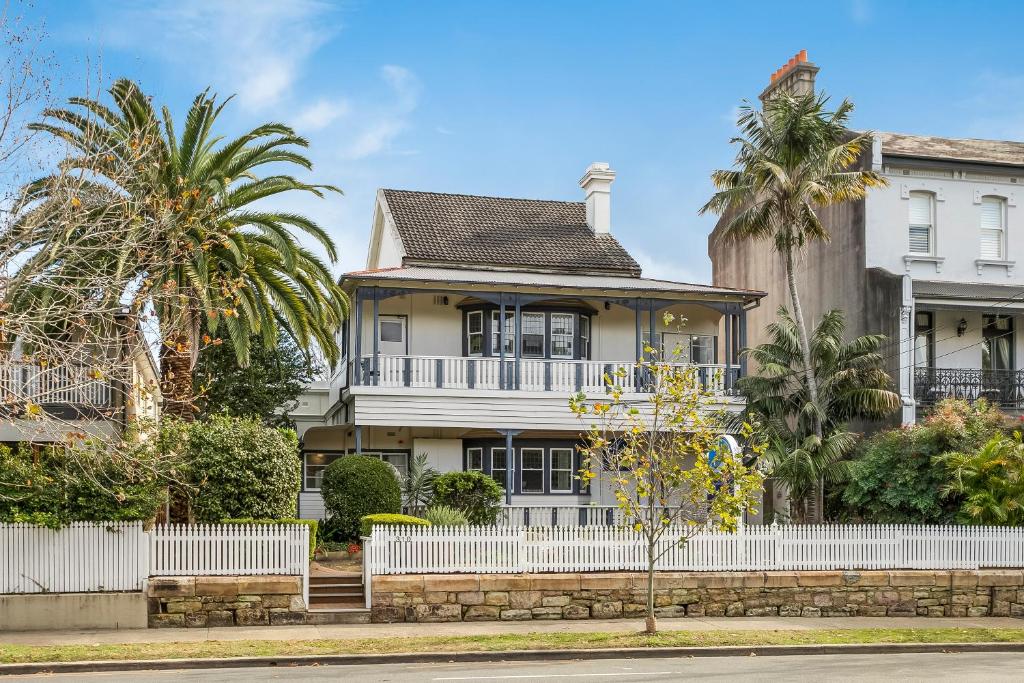 a house with a white fence and palm trees at The North Shore Hotel in Sydney