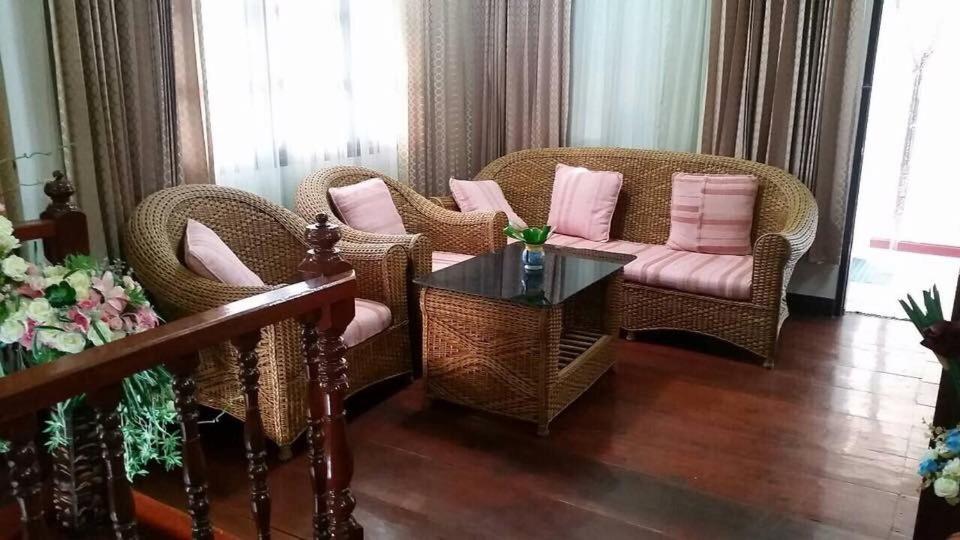 uma sala de estar com cadeiras de vime e uma mesa em Napakarn Homestay em Chiang Rai