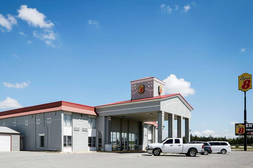 a truck parked in front of a building with a clock tower at Super 8 by Wyndham Elk City in Elk City