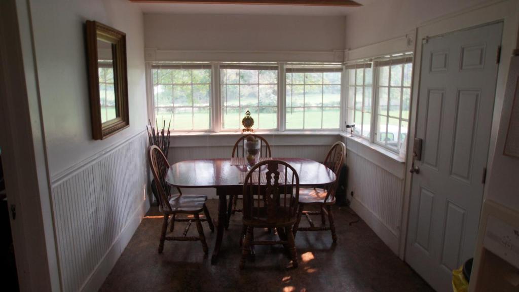 a dining room with a table and chairs and windows at Near Chiefs and Royals Stadium - 4 beds in Independence