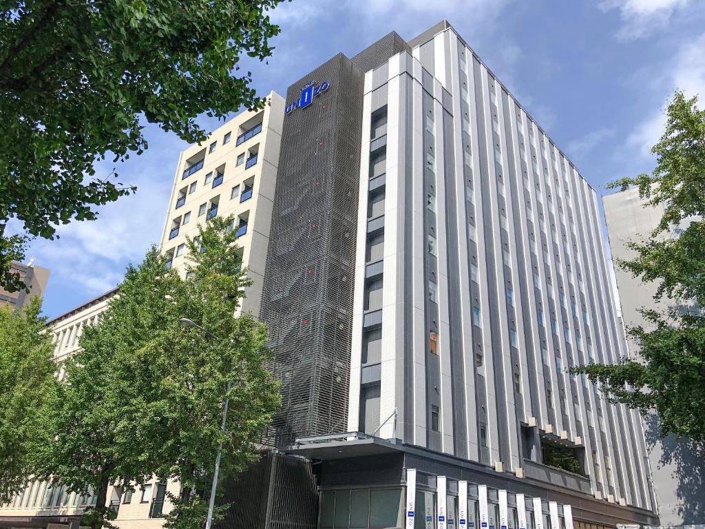 福岡市にあるホテルユニゾ博多駅博多口の青い看板が立つ高い白い建物