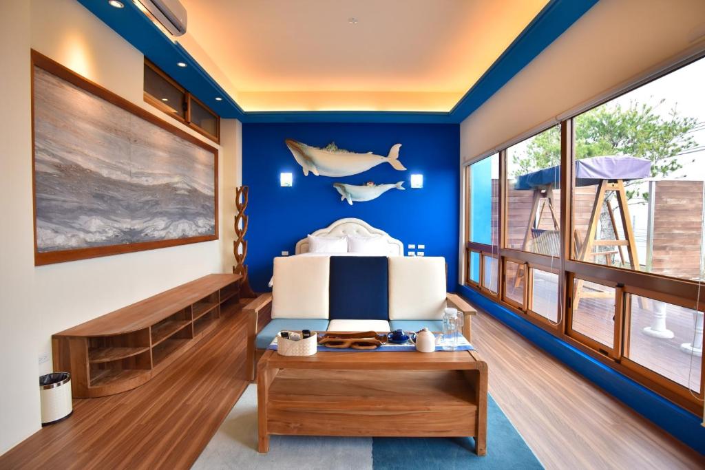 Habitación con paredes azules, cama y mesa. en Rainbow Hill House en Shigang
