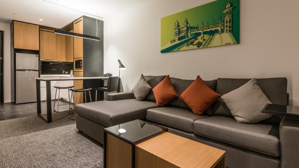 A large sectional anchors a lounge beside the suite kitchenette and dining counter.