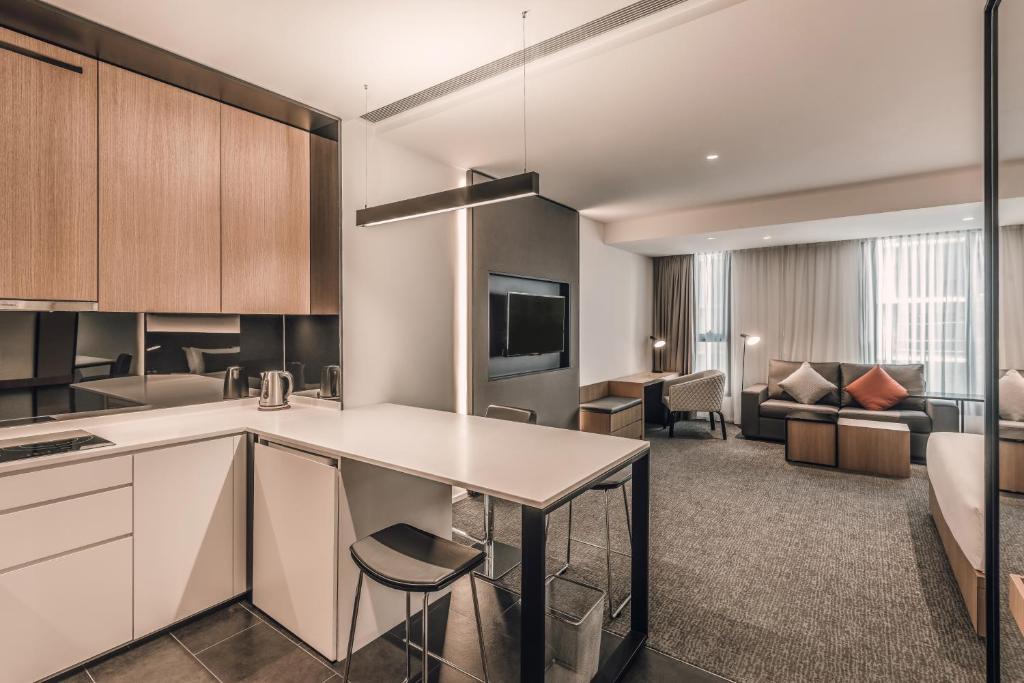 An open-plan suite combines a compact kitchen, breakfast counter and furnished sitting area.