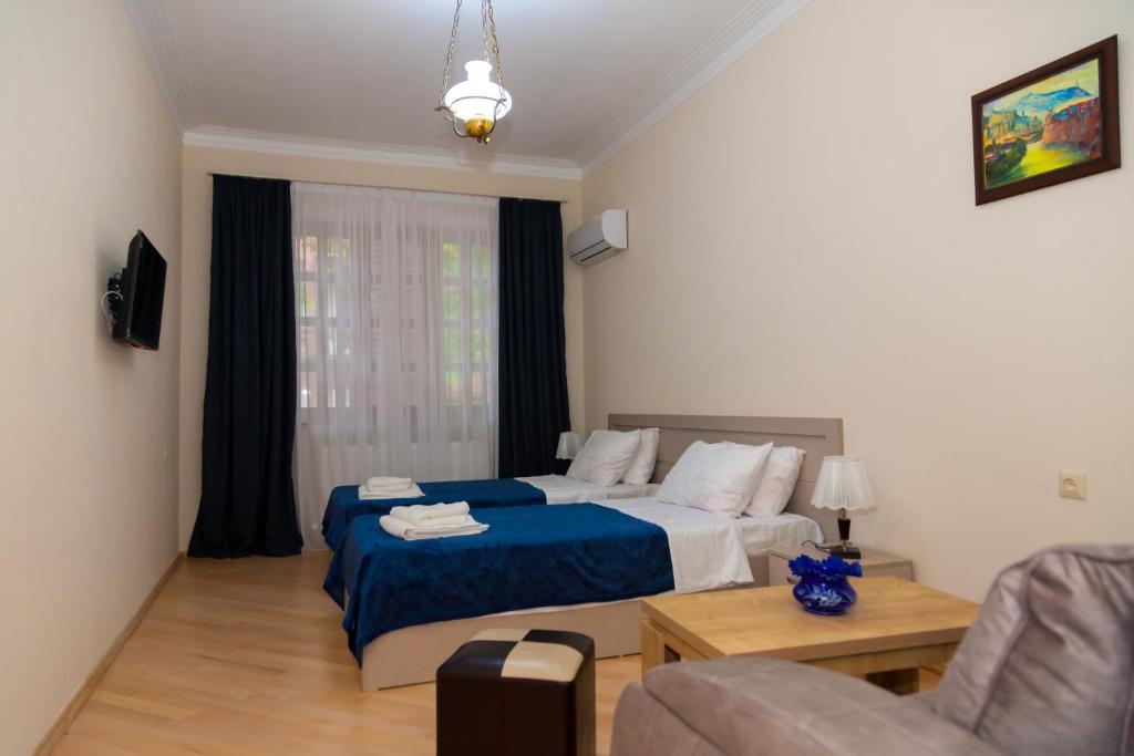 a bedroom with a bed and a couch and a table at Holiday Rooms in Tbilisi City