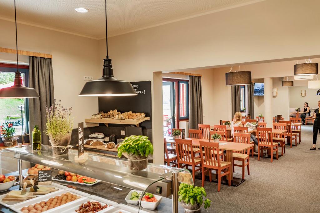 restauracja ze stołami i krzesłami oraz bufetem w obiekcie JUFA Hotel Maria Lankowitz w mieście Maria Lankowitz
