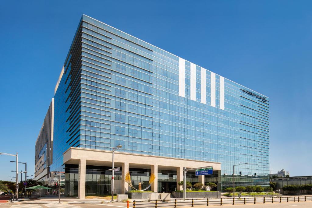 een groot blauw gebouw met veel ramen bij Golden Tulip Incheon Airport Hotel in Incheon