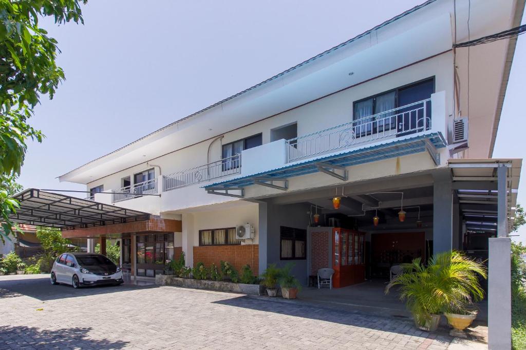een gebouw waar een auto voor geparkeerd staat bij RedDoorz near Sam Ratulangi Airport Manado in Manado