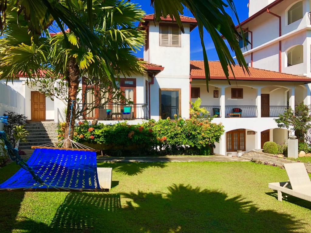 a yard with a hammock in front of a house at Elegant Hotel in Kandy