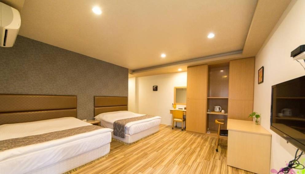 Yilan Jimmy Villa في مدينة ييلان: غرفة فندقية بسريرين وتلفزيون بشاشة مسطحة
