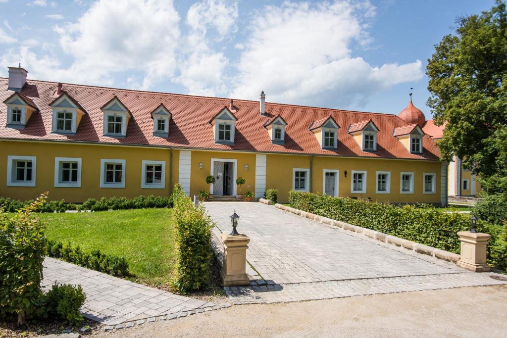 un grand bâtiment jaune avec un toit rouge dans l'établissement Remise Thurn, à Heroldsbach