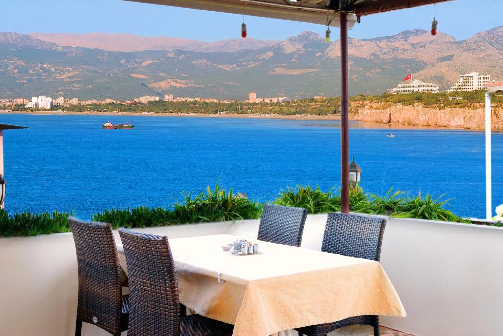 a table and chairs with a view of the water at Ozmen Hotel in Antalya
