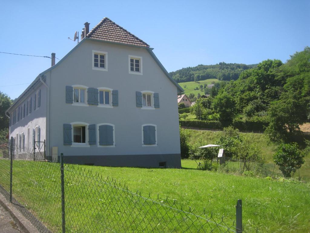 a white house on a hill with a fence at Gite en pleine verdure au coeur du village in Lapoutroie